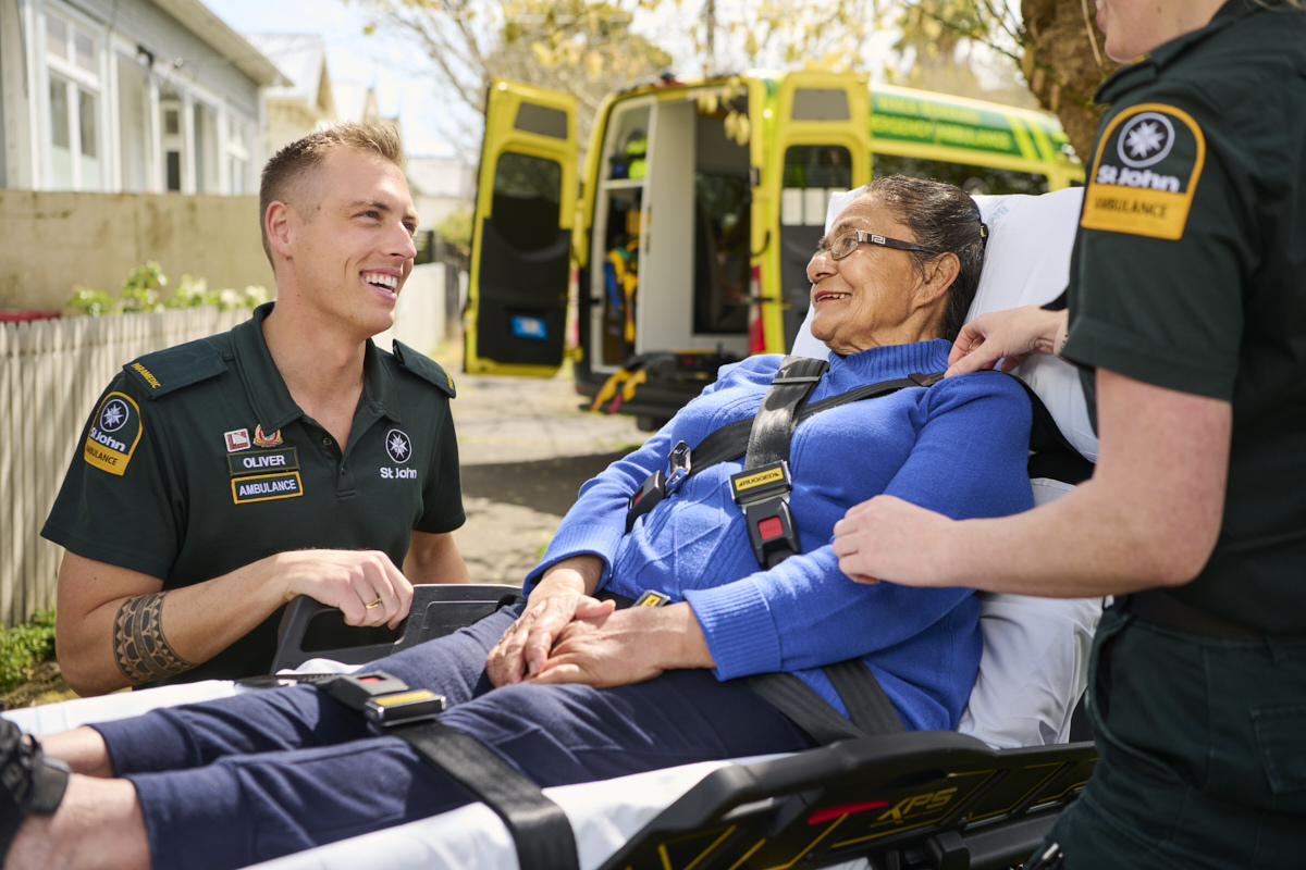 Paramedic and patient smiling outside of an ambulance