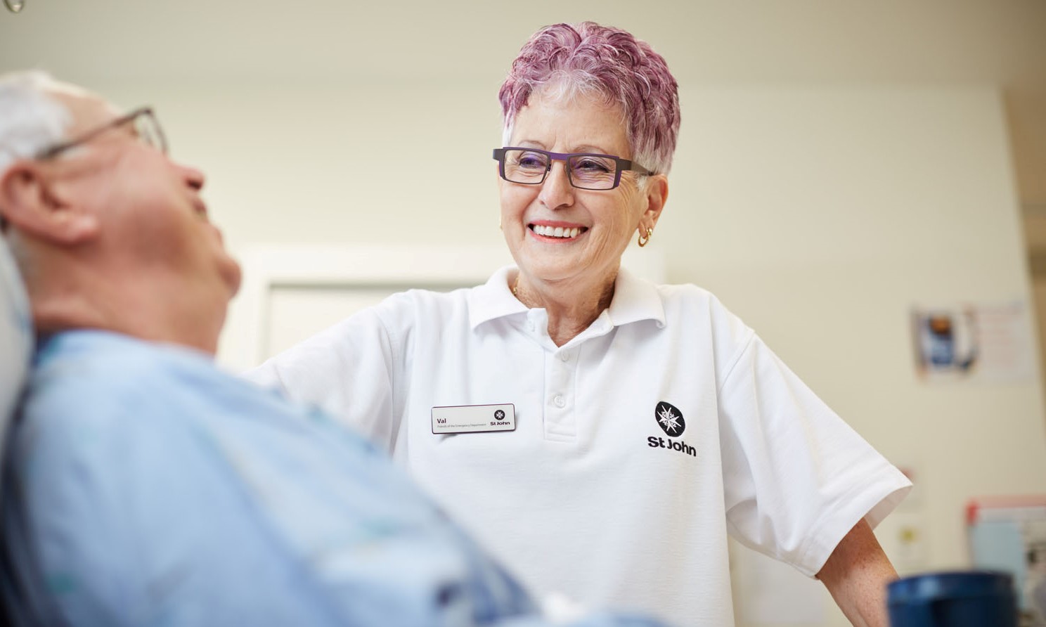 St John hopsital carer talking with patient at their bedside