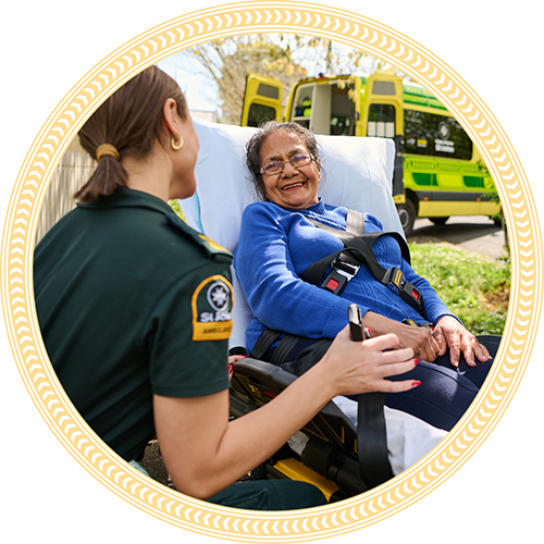 Ambulance officer standing next to a patient on a stretcher