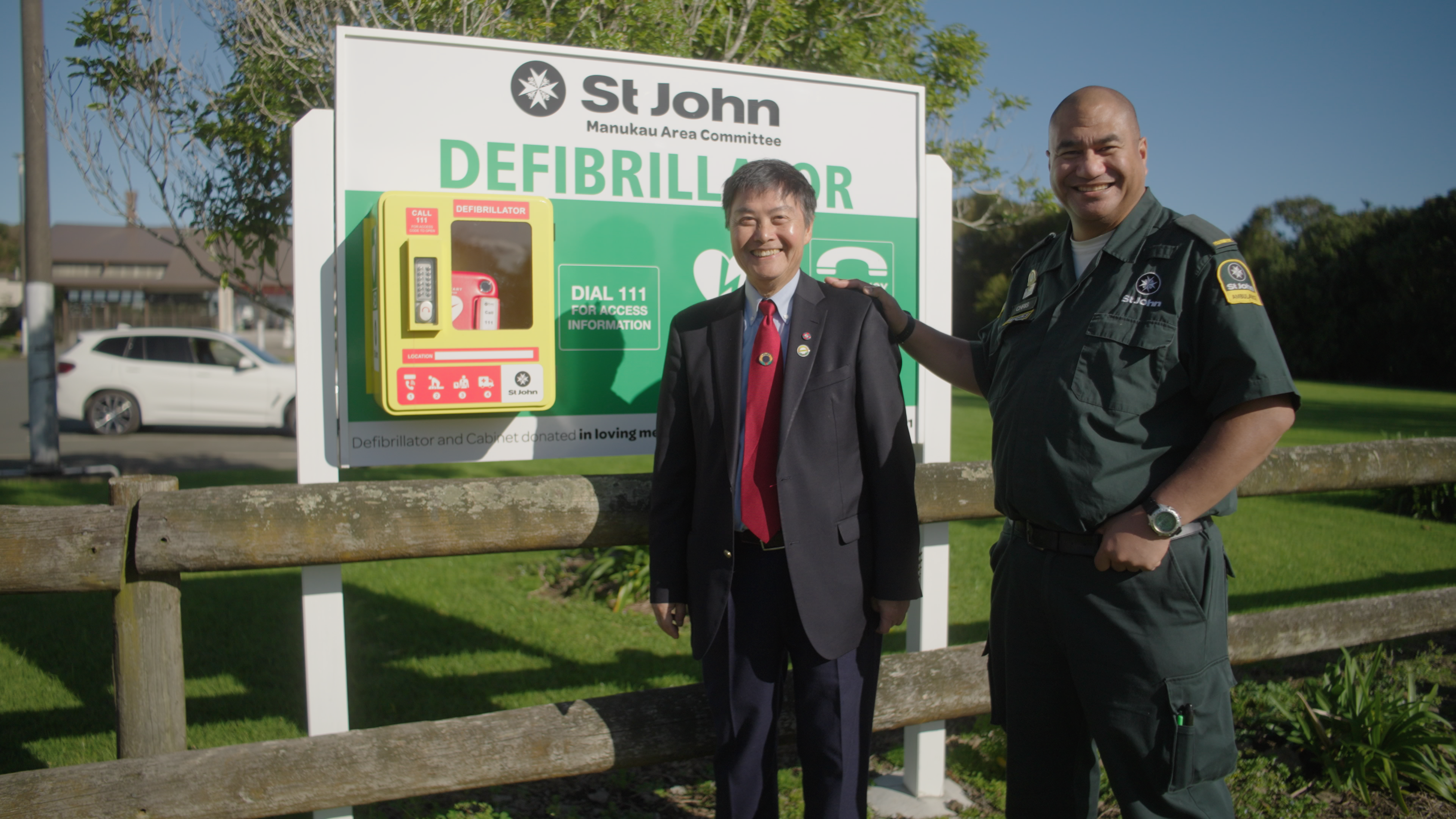 Ambulance officer with donation of defib on local community