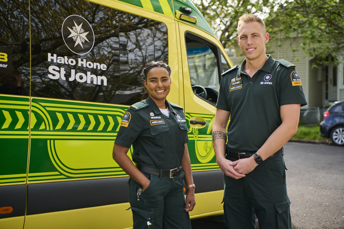 2 paramedics smiling outside of ambulance