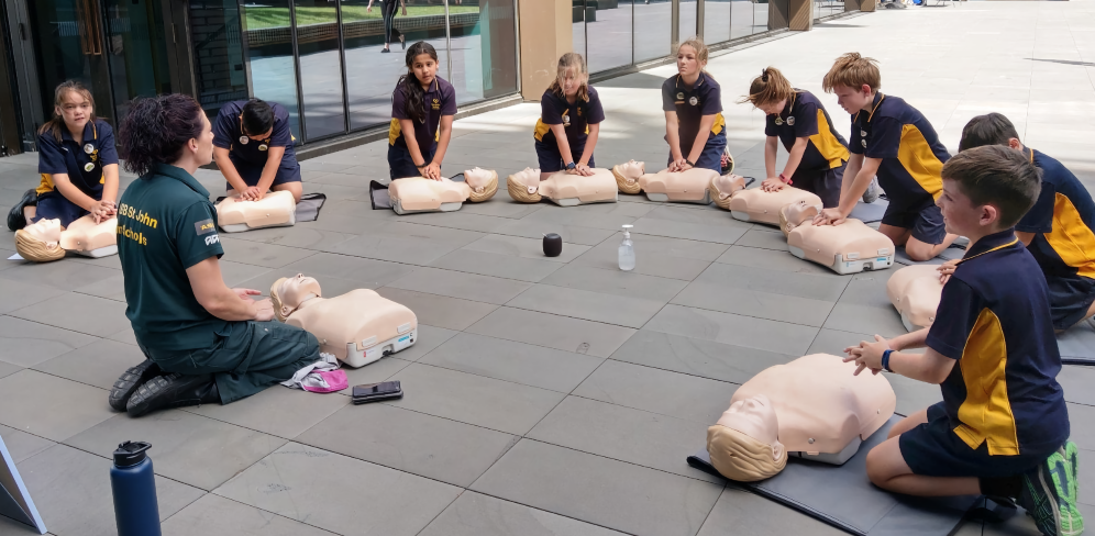 Students practising CPR with a tutor Students practising CPR with a tutor