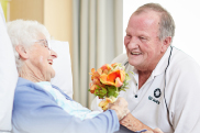 Hospital volunteer giving patient flowers