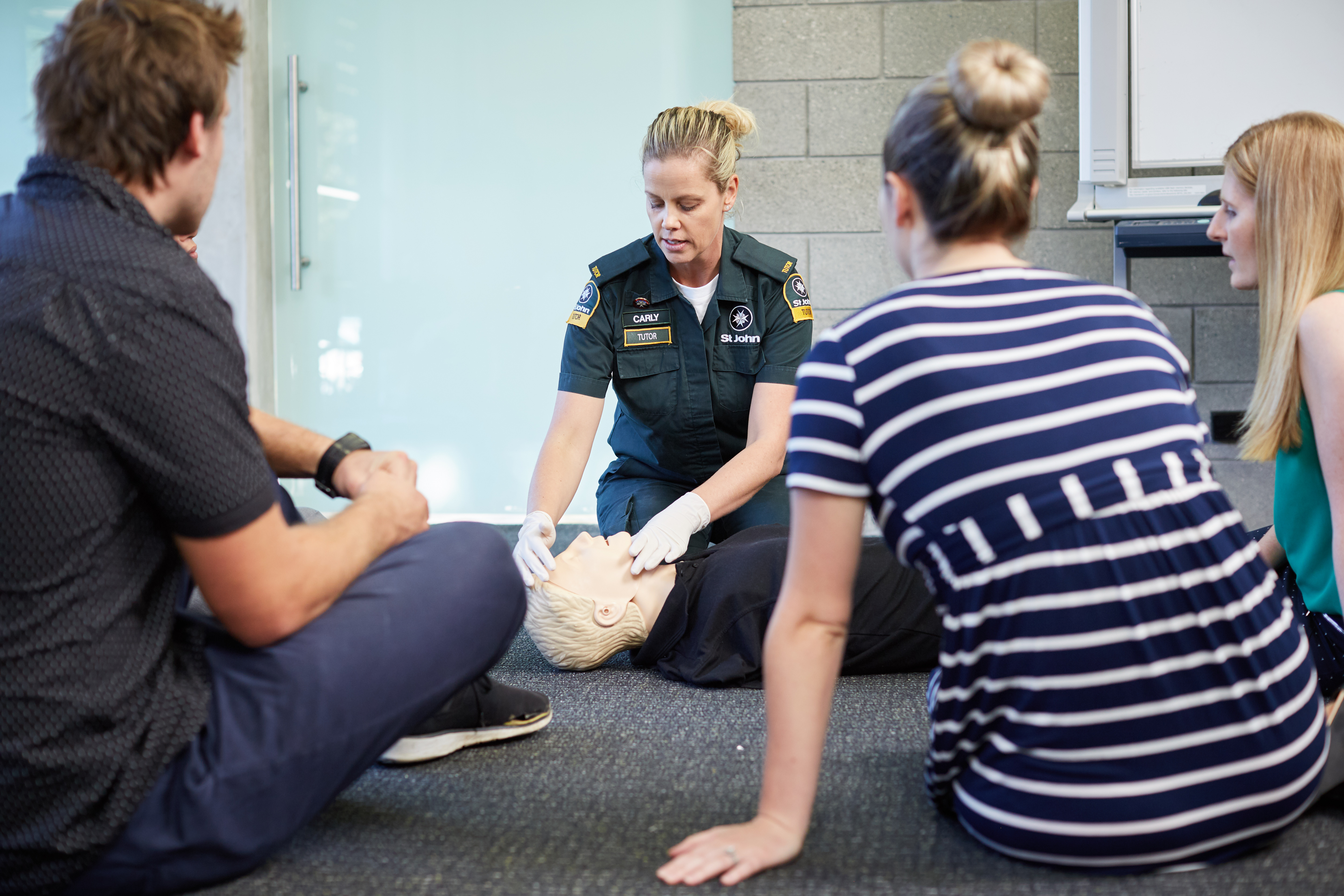 First aid tutor showing students CPR