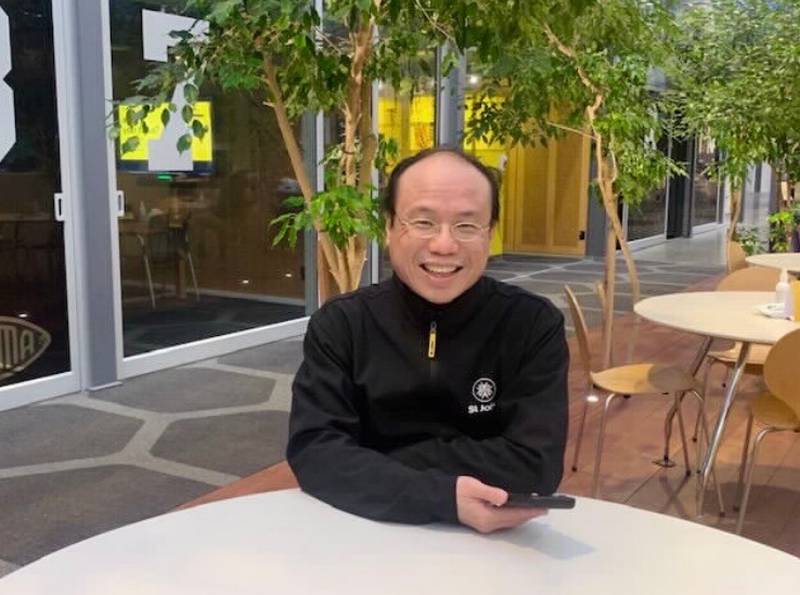 Eugene Lok from ASB, sitting at a table in a courtyard