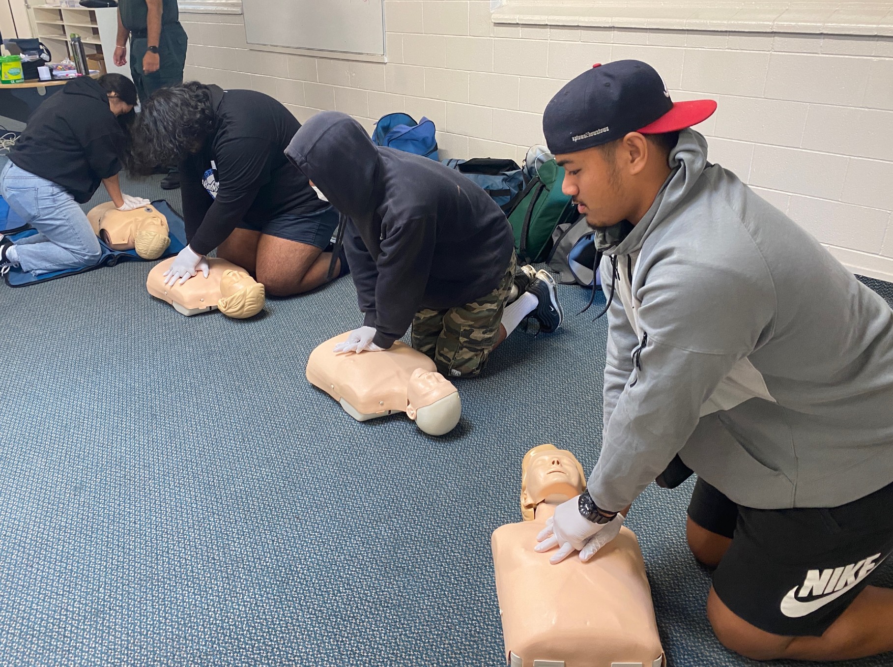 students practicing cpr on a dummy