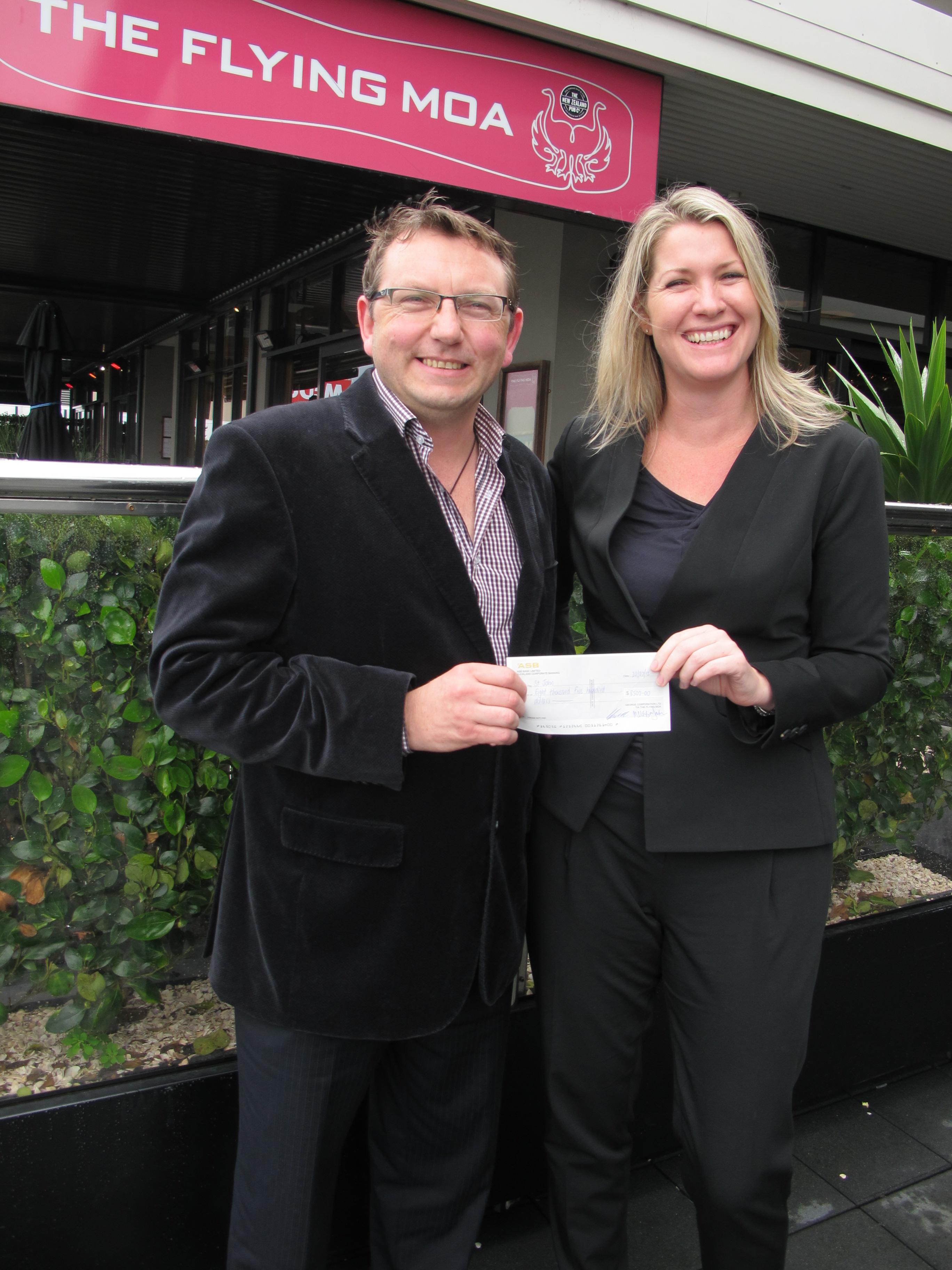 Lance Campbell, the Director of The Flying Moa presents a cheque for $8500 to Rachel Brooke, Acting Customers and Services Manager for St John.